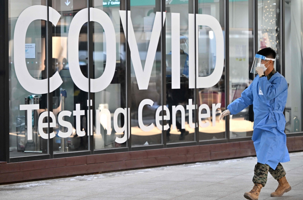 A health worker walks in front of a Covid-19 testing centre at Incheon International Airport, west of Seoul on January 3, 2023. (Photo by Jung Yeon-je / AFP)