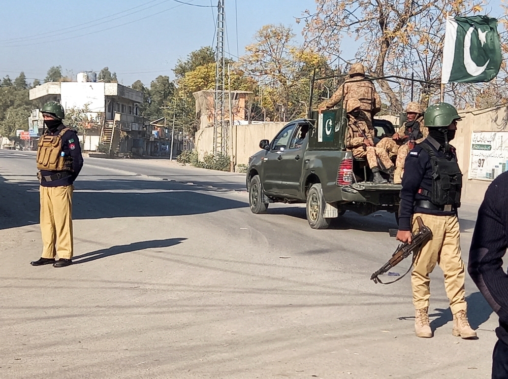  A Pakistani army vehicle patrols past police officers standing guard along a road near a cantonment area in Bannu, Pakistan, on December 21, 2022. File Photo / Reuters