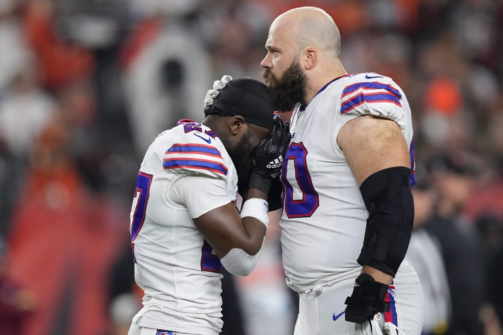 In this file photo taken on January 2, 2023, Tre'Davious White and Mitch Morse of the Buffalo Bills, react to teammate Damar Hamlin, collapsing after making a tackle against the Cincinnati Bengals during the first quarter at Paycor Stadium in Cincinnati, Ohio. (Photo by Dylan Buell / Getty Images NA / AFP)