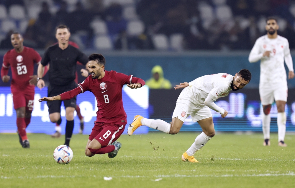 Qatar's Ali Assadalla in action with Bahrain's Mohamed Marhoon during their Arabian Gulf Cup25 Group B match at the  Al-Minaa Olympic Stadium, Basra, Iraq on January 10, 2023.  REUTERS/Thaier Al-Sudani
 