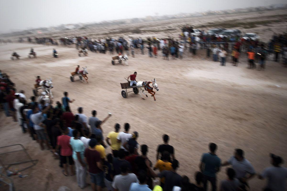 File Photo: Bahraini men ride their donkey carts as they compete in a local race in the village of Saar, West of the capital Manama, on September 4, 2015. (AFP/Getty Images)

