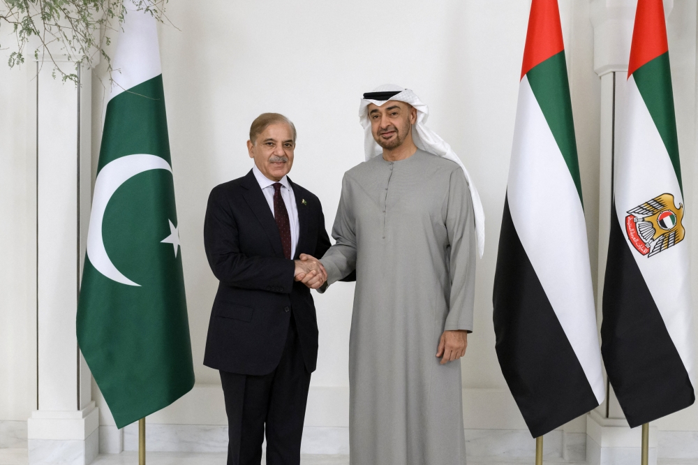 This handout image provided by the UAE Presidential court on January 12, 2023 shows UAE President Sheikh Mohamed bin Zayed al-Nahyan posing for a picture with Shehbaz Sharif, Prime Minister of Pakistan, prior to their meeting, at Al Shati Palace in Abu Dhabi. (Photo by UAE PRESIDENTIAL COURT / AFP)