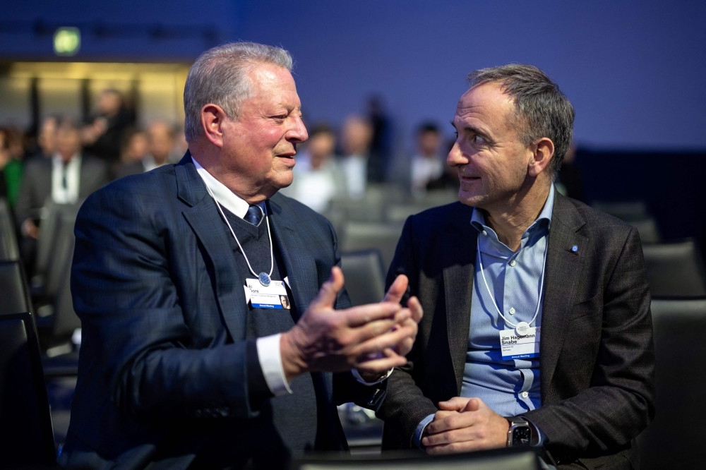 Former US vice-president and climate campaigner Al Gore (L) speaks with Siemens chairman Jim Hagemann Snabe at the Congress centre during the World Economic Forum (WEF) annual meeting in Davos, on January 17, 2022. (Photo by Fabrice COFFRINI / AFP)