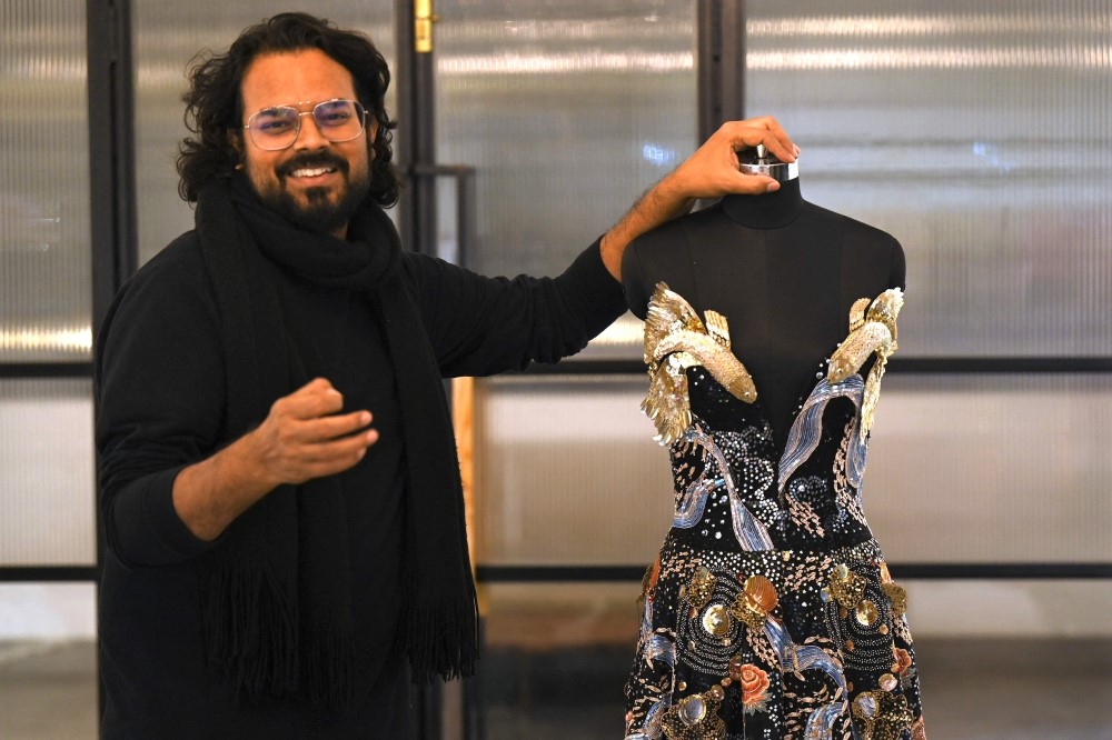 In this photograph taken on January 13, 2023, Indian fashion designer Rahul Mishra stands beside his new collection at his workshop in Noida. (Photo by Money Sharma / AFP)