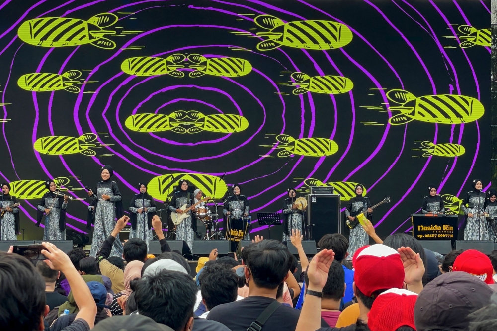 This picture taken on January 6, 2023 shows members of the all-female hijab-clad Nasida Ria band performing on stage in front of an audience at a festival in Jakarta. (Photo by AGNES ANYA / AFP)