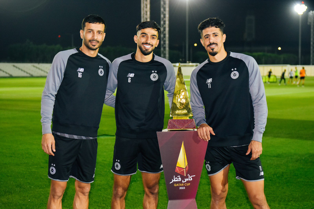 FROM LEFT: Al Sadd's Boualem Khoukhi, Tarek Salman and Baghdad Bounedjah pose with the Qatar Cup trophy. 