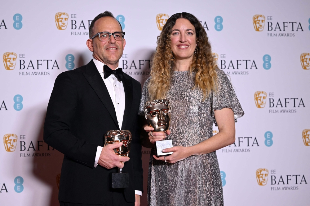 US decorator and production designer Florencia Martin and Anthony production designer Anthony Carlino pose with the award for Best production design for 'Babylon' during the BAFTA British Academy Film Awards ceremony at the Royal Festival Hall, Southbank Centre, in London, on February 19, 2023. (Photo by JUSTIN TALLIS / AFP)