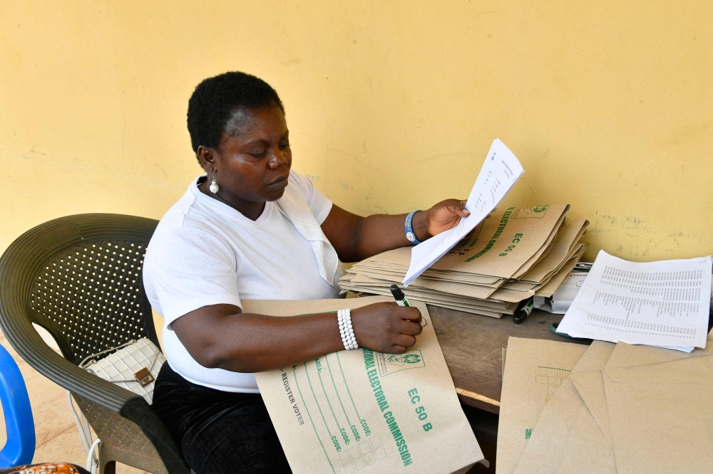 An official of Independent National Electoral Commission (INEC) writes on document ahead of the February 25 presidential election at the commission's headquarters at Awka in Anambra State, southeast Nigeria, on February 16, 2023. (Photo by Pius Utomi Ekpei / AFP)
 