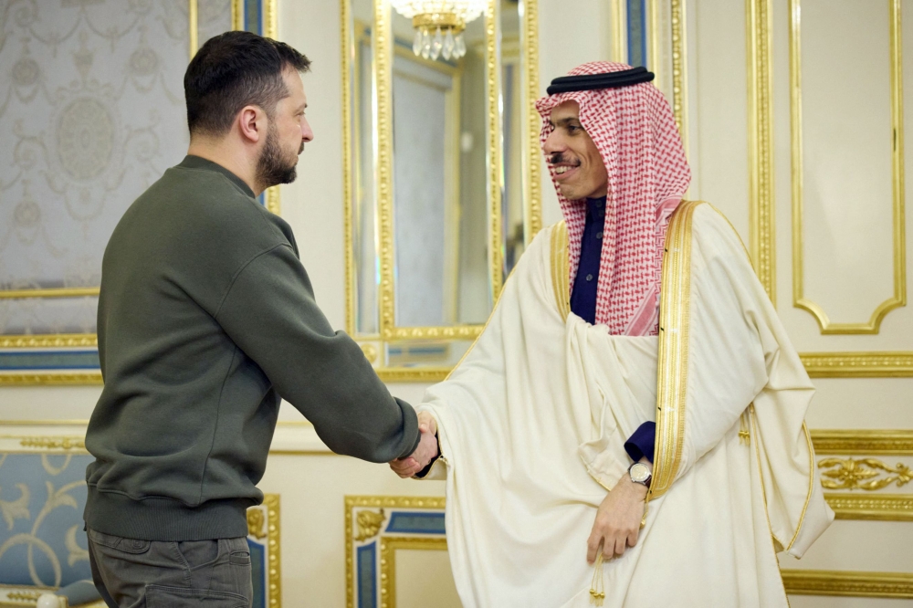 This handout picture taken and released by the Ukrainian Presidential press service on February 26, 2023, shows Ukrainian President Volodymyr Zelensky (L) shaking hands with Foreign Minister of the Kingdom of Saudi Arabia Prince Faisal bin Farhan Al Saud (R) prior to their talks in Kyiv. (Photo by Handout / Ukrainian Presidential Press Service / AFP)