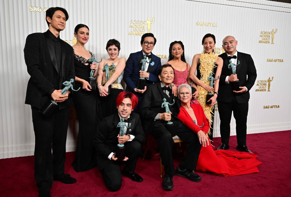 Actors Michelle Yeoh, Ke Huy Quan, Stephanie Hsu, Jamie Lee Curtis, James Hong, Jenny Slate, Harry Chum Jr. and cast pose with the award for Outstanding Performance by a Cast in a Motion Picture for 