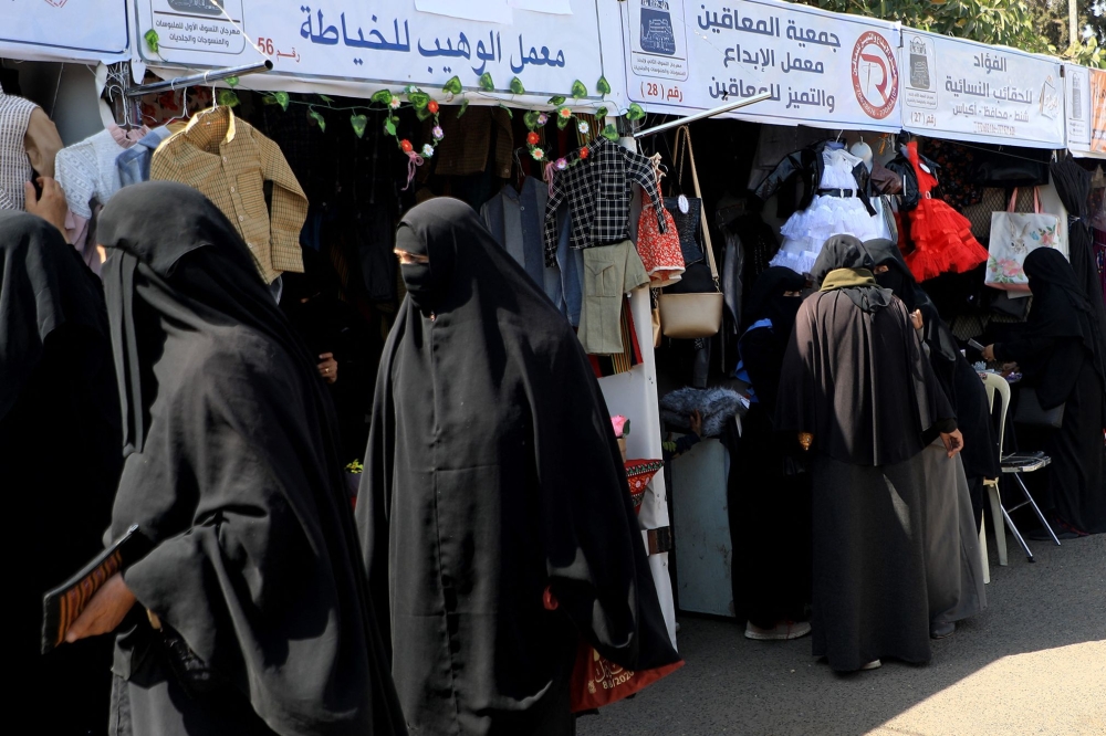 People shop at an exhibition of local products in the rebel-held Yemeni capital Sanaa, on February 27, 2023. (Photo by Mohammed Huwais / AFP)