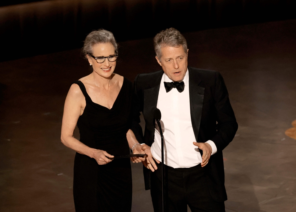 HOLLYWOOD, CALIFORNIA - MARCH 12: (L-R) Andie MacDowell and Hugh Grant speaks onstage during the 95th Annual Academy Awards at Dolby Theatre on March 12, 2023 in Hollywood, California. Kevin Winter/Getty Images/AFP (Photo by KEVIN WINTER / GETTY IMAGES NORTH AMERICA / Getty Images via AFP)