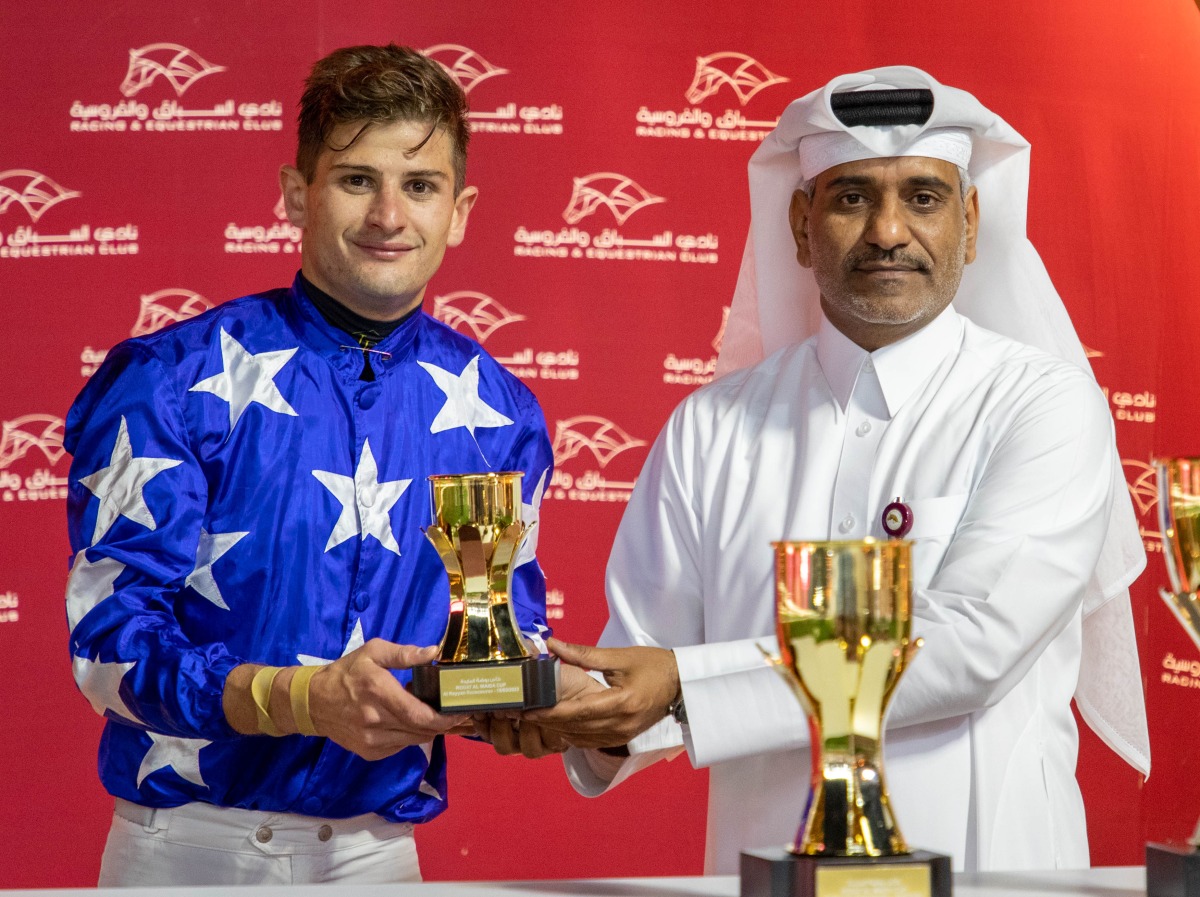 Al Uqda Complex Manager Abdulaziz Jassim Al Boenain presents trophy to Lukas Delozier. 