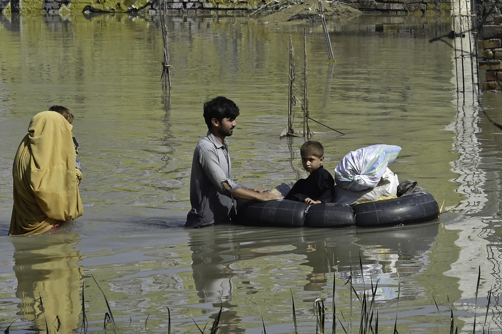 A family wades through a flood hit area following heavy monsoon rains in Charsadda district of Khyber Pakhtunkhwa on August 29, 2022.  File photo / AFP
