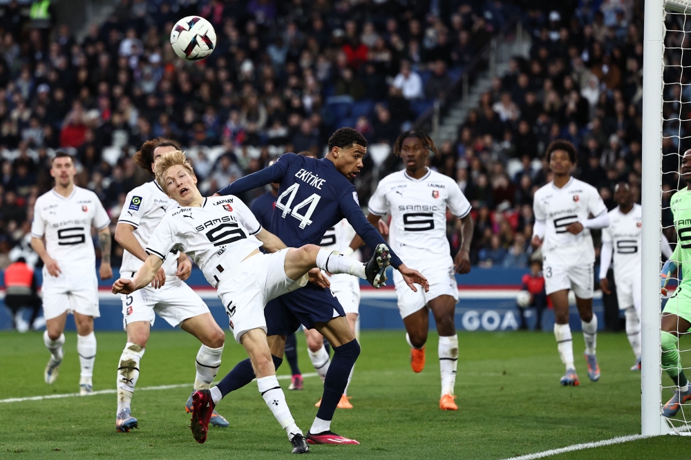 Rennes' Norwegian defender Birger Meling fights for the ball with Paris Saint-Germain's French forward Hugo Ekitike during the French L1 football match between Paris Saint-Germain (PSG) and Stade Rennais FC at The Parc des Princes Stadium in Paris on March 19, 2023. (Photo by Anne-Christine POUJOULAT / AFP)