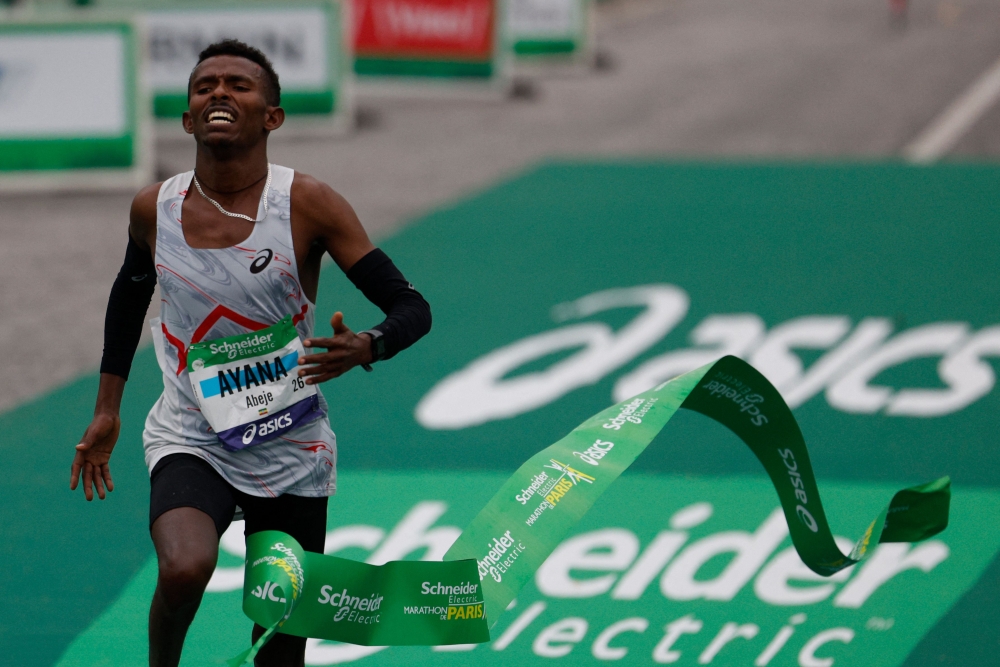 Ethiopia's Abeje Ayana crosses the finish line to win the 2023 Paris Marathon, at the Arc de Triomphe in Paris on April 2, 2023. Photo by Geoffroy Van der Hasselt / AFP