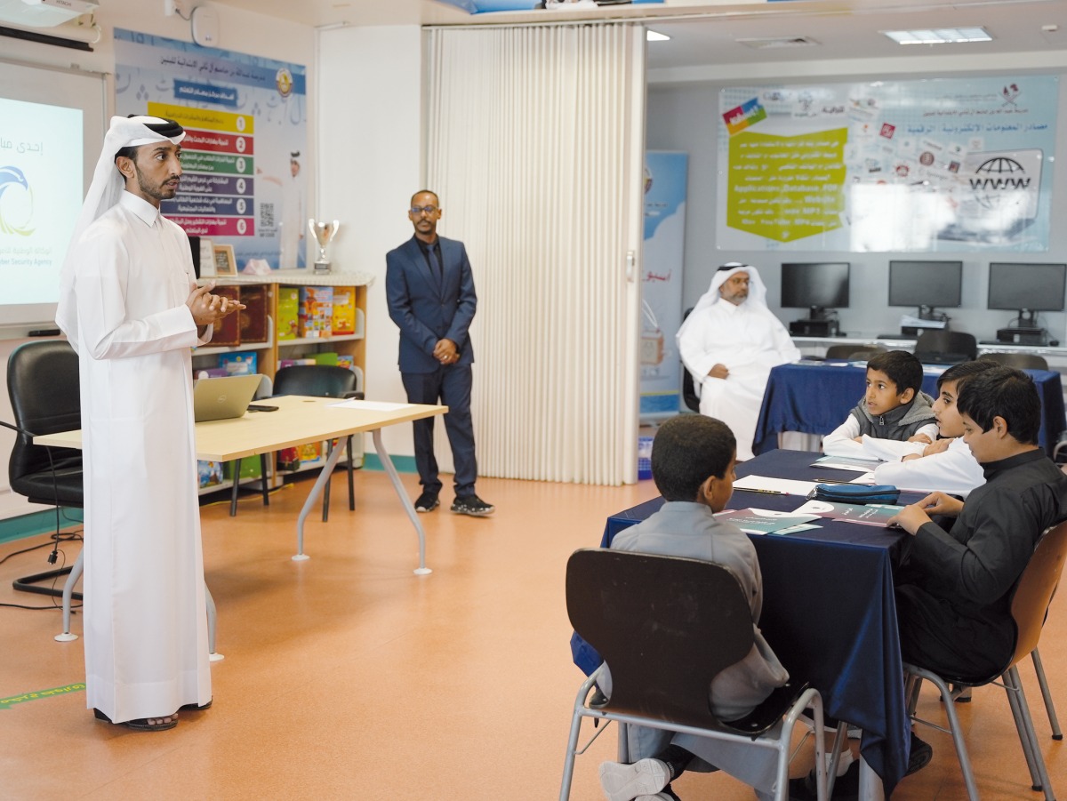 An official from National Cyber Security Agency educating a group of students about cyber risks.