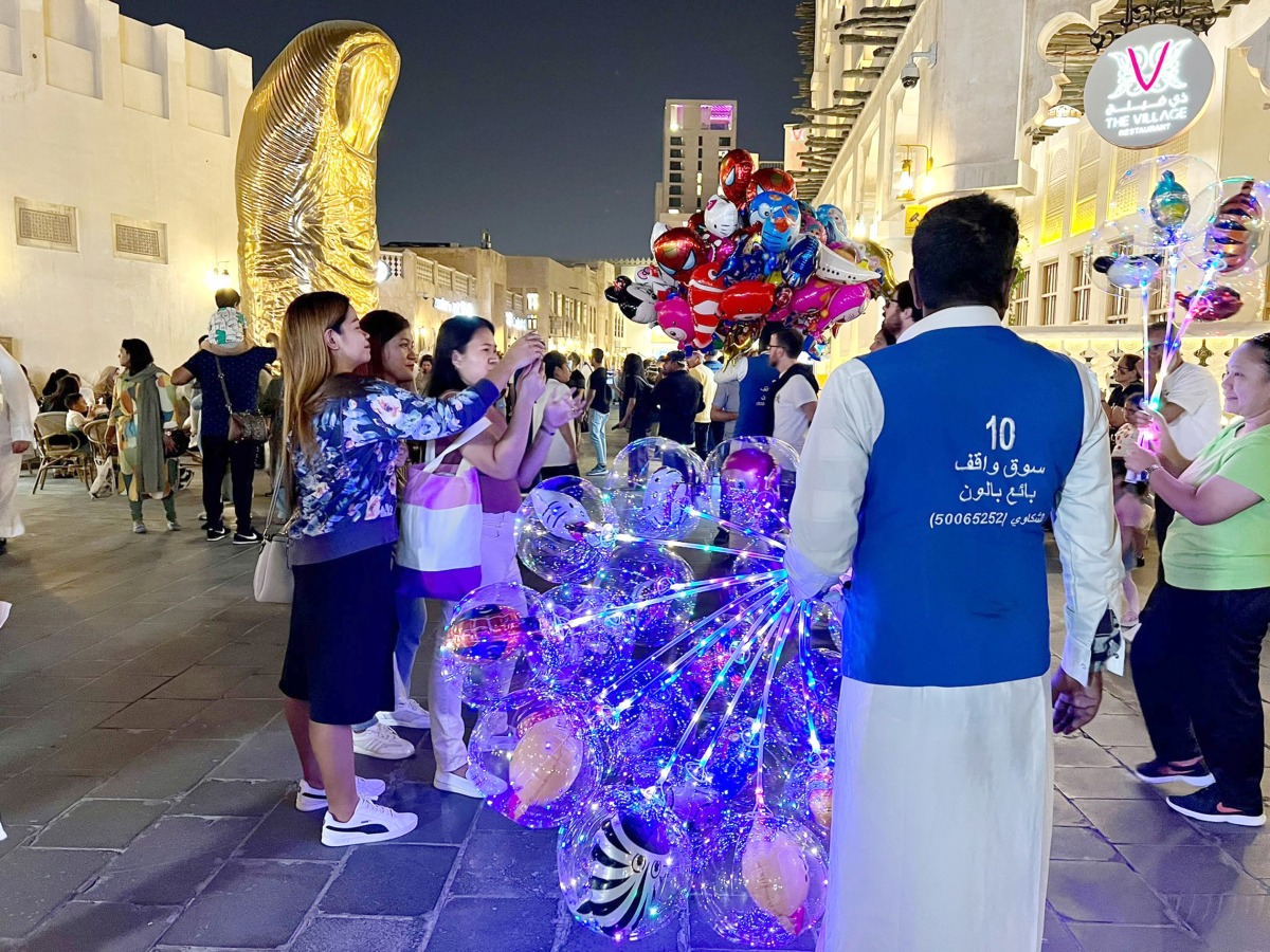 Visitors take photos while enjoying the lively atmosphere at Souq Waqif. Pic: Amr Diab