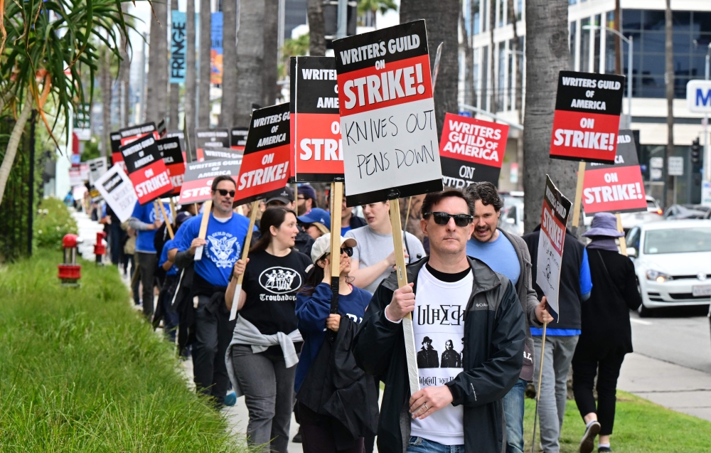 Writer Eric Heisserer hold his sign on the picket line on the fourth day of the strike by the Writers Guild of America in front of Netflix in Hollywood, California, on May 5, 2023. Photo by Frederic J. BROWN / AFP