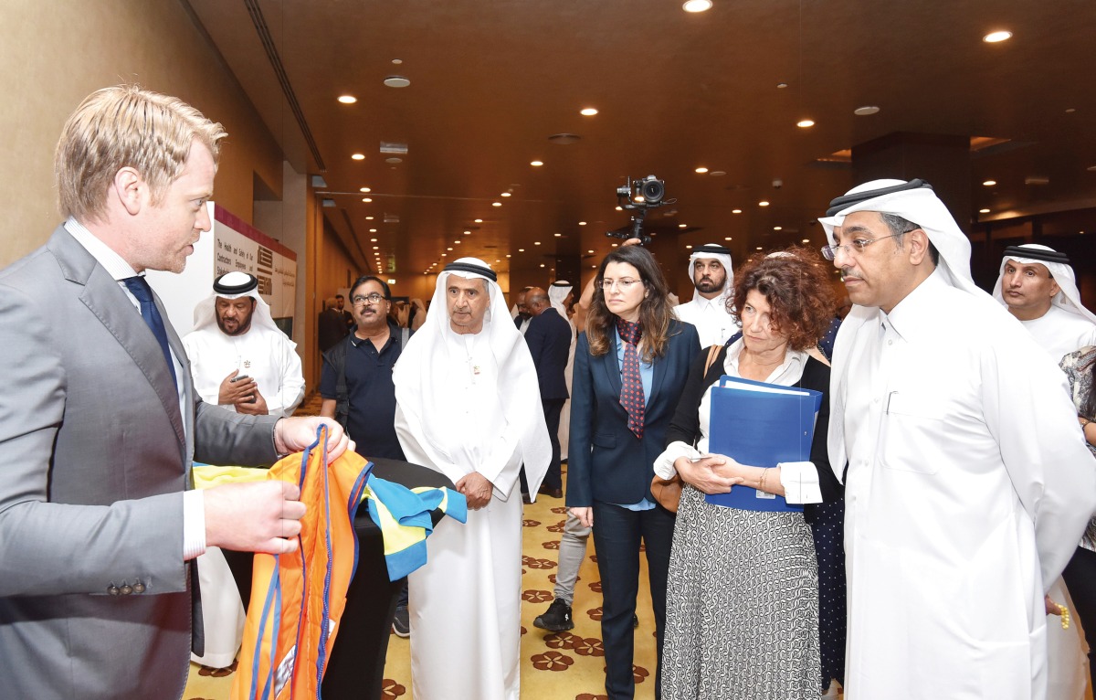 Minister of Labour H E Dr. Ali bin Smaikh Al Marri (right) interacts with a participant on the sidelines of International Conference on Occupational Heat Stress, in Doha, yesterday.