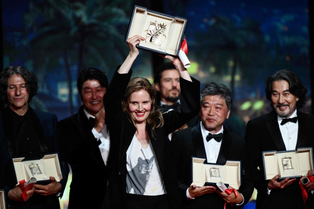 British director Jonathan Glazer, South Korean actor Song Kang-ho Japanese, French director Justine Triet, Japanese director Kore-eda Hirokazu and Japanese actor Koji Yakusho pose on stage during the closing ceremony of the 76th edition of the Cannes Film Festival in Cannes, southern France, on May 27, 2023.