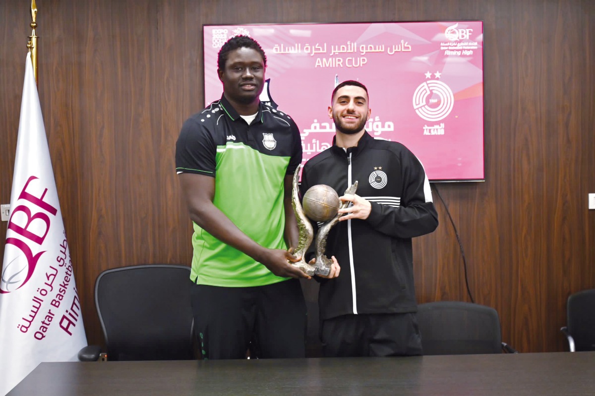 Al Ahli's Ndoye Elhadj Seydou (left) and Al Sadd's Faisal Nabil Abuissa pose with the Amir Cup trophy.