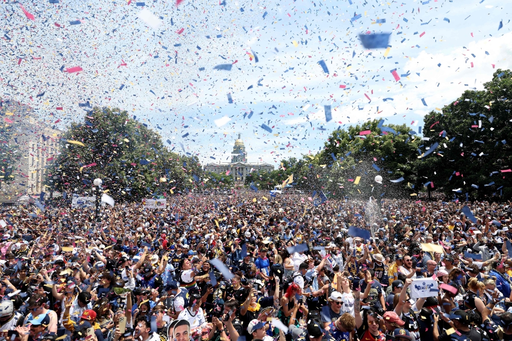 Confetti flies over the crowd during the Denver Nuggets victory parade and rally after winning the 2023 NBA Championship at Civic Center Park on June 15, 2023 in Denver, Colorado. (Photo by Matthew Stockman / Getty Images via AFP)