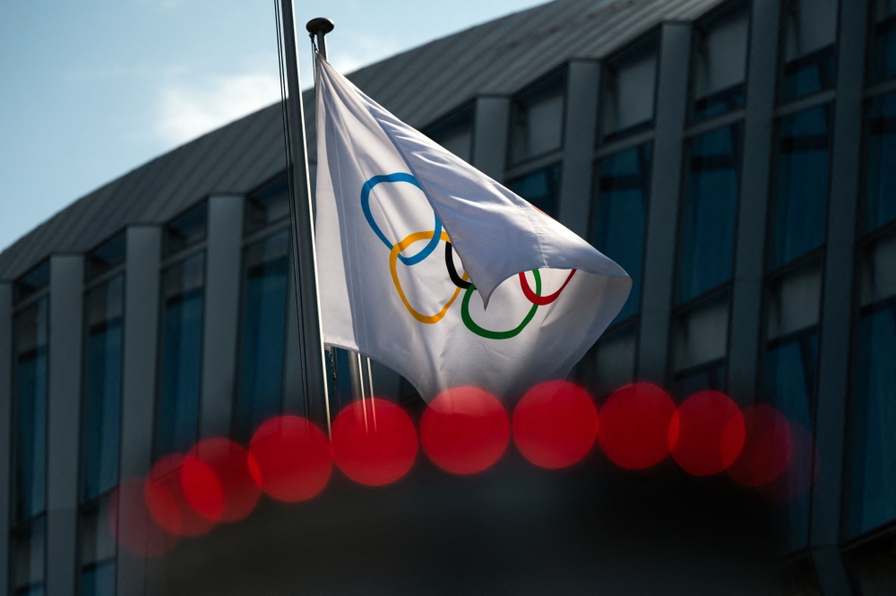 This file photo taken on March 8, 2021 shows the Olympic flag next to the headquarters of the International Olympic Committee (IOC) in Lausanne. (Photo by Fabrice Coffrini / AFP)