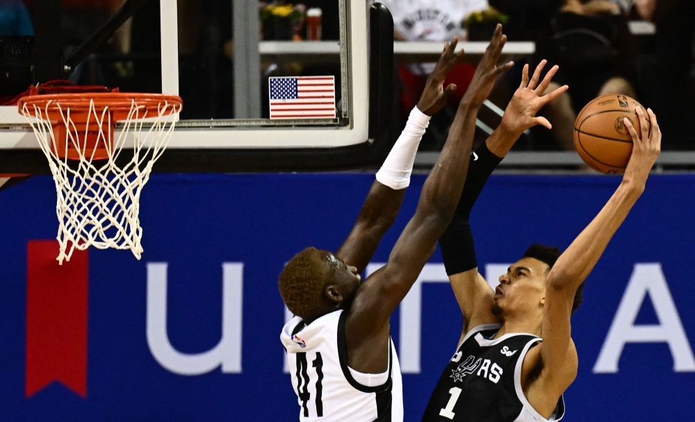 Portland Trail Blazers' Ibou Badji (L) fails to block a point by San Antonio Spurs' Victor Wembanyama (R) during the NBA Summer League game between the San Antonio Spurs and Portland Trail Blazers, at the Thomas and Mack Center in Las Vegas, Nevada, on July 9, 2023. (Photo by Patrick T. Fallon / AFP)