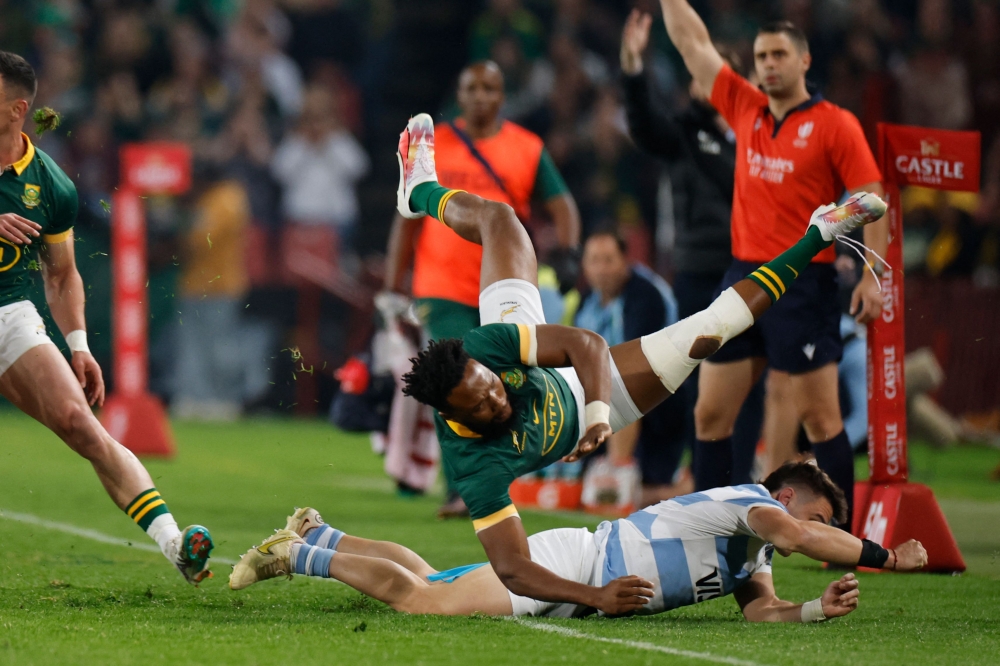 Argentina's wing Mateo Carreras (Bottom R) tackles South Africa'scenter Lukhanyo Am during the Rugby Championship final-round match between South Africa and Argentina at Ellis Park in Johannesburg on July 29, 2023. (Photo by WIKUS DE WET / AFP)
