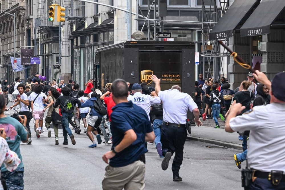 Plates are thrown near Chelsea as members of the NYPD respond to the disruptions caused by large crowds during a 