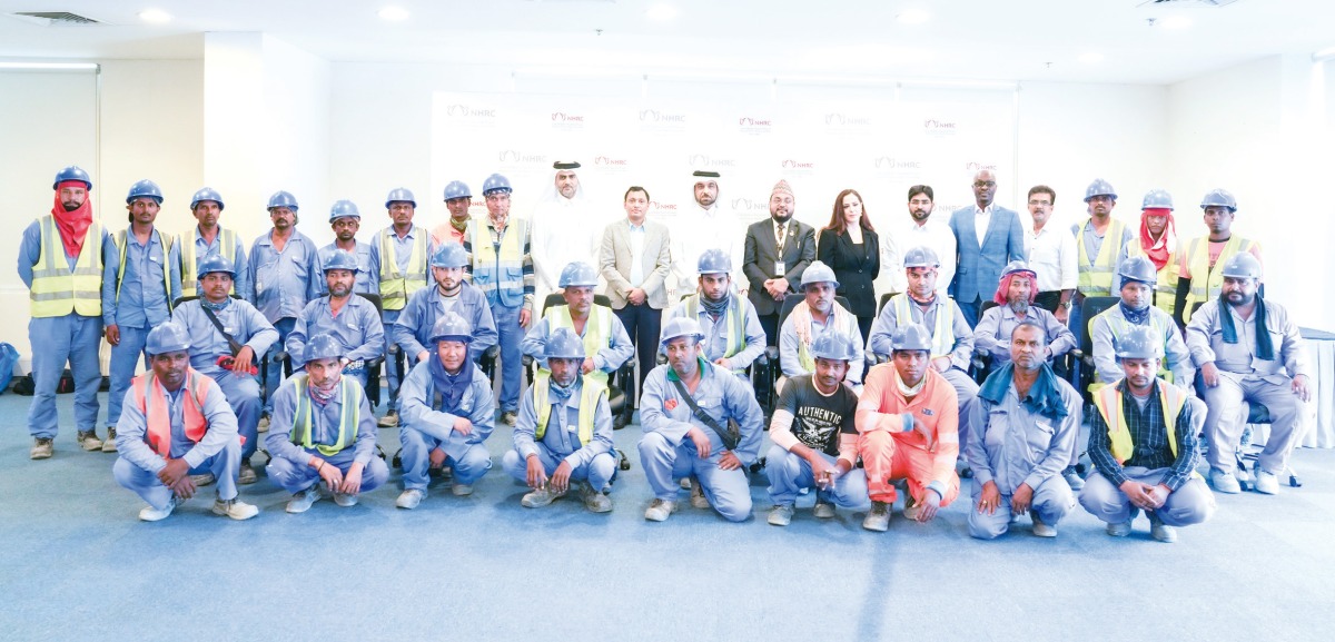 NHRC Secretary-General H E Sultan bin Hassan Al Jamali with workers during the seminar.