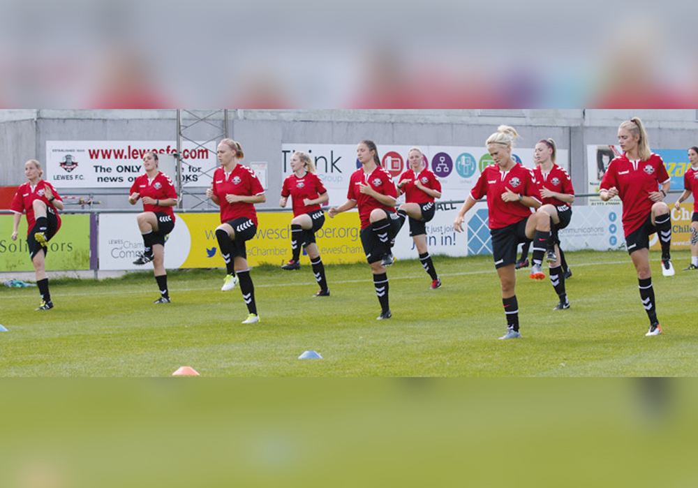 Female football players warm up before a match.