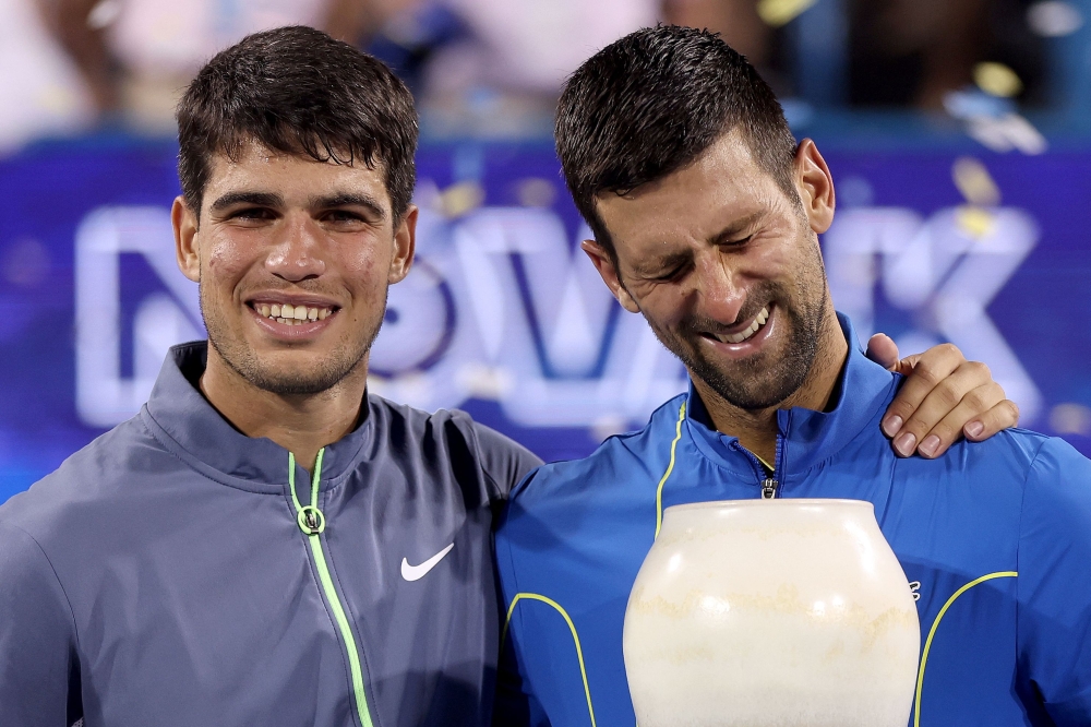 Carlos Alcaraz of Spain and Novak Djokovic of Serbia pose with their trophies after the final of the Western & Southern Open at Lindner Family Tennis Center on August 20, 2023 in Mason, Ohio. Photos by Matthew Stockman/Getty Images/AFP