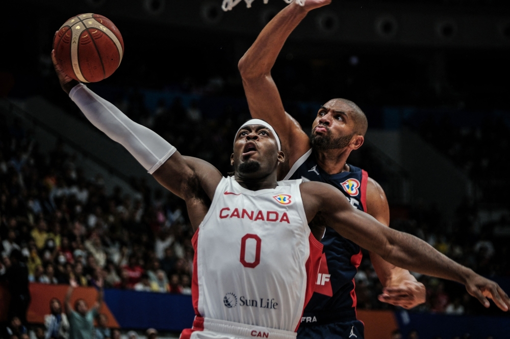 Canada's Luguentz Dort (left) scores as France's Nicolas Batum tries to block during the opening ceremony before the FIBA Basketball World Cup group H match between Canada and France at Indonesia Arena in Jakarta on August 25, 2023. (Photo by Yasuyoshi Chiba / AFP)