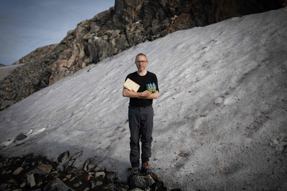 Director of Research at the French National Centre for Scientific Research (CNRS), biologist Eric Marechal, poses for a photograph holding an original edition of 1819 of Arctic Explorator John Ross book 