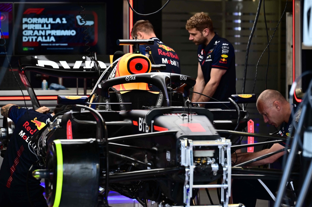 A mechanic works on the car of Red Bull Racing's Dutch driver Max Verstappen in the pits of the Monza Circuit ahead of the Italy's Formula One Grand Prix, on august 31, 2023, in Monza northern Italy. Photo by Marco BERTORELLO / AFP