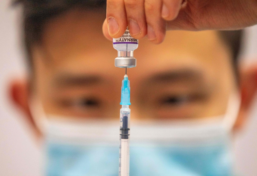 In this file photo taken on December 21, 2021, a medical worker prepares a dose of a Covid-19 vaccine at a temporary vaccination centre set up in the Titanic Exhibition Centre in Belfast. (Photo by Paul Faith / AFP)