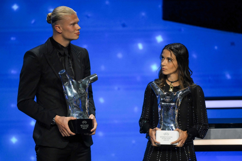 Manchester City's Norwegian striker Erling Haaland (left) and FC Barcelona's Spanish midfielder Aitana Bonmati pose with their season 2022/2023 men's and women's player of the year awards during the UEFA Champions League group stage draw ceremony at The Grimaldi Forum in the Principality of Monaco, on August 31, 2023. (Photo by Nicolas Tucat / AFP)