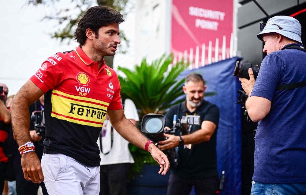 Ferrari's Spanish driver Carlos Sainz Jr (L) arrives prior to the third practice session in Monza on September 2, 2023. (Photo by Ben Stansall / AFP)
