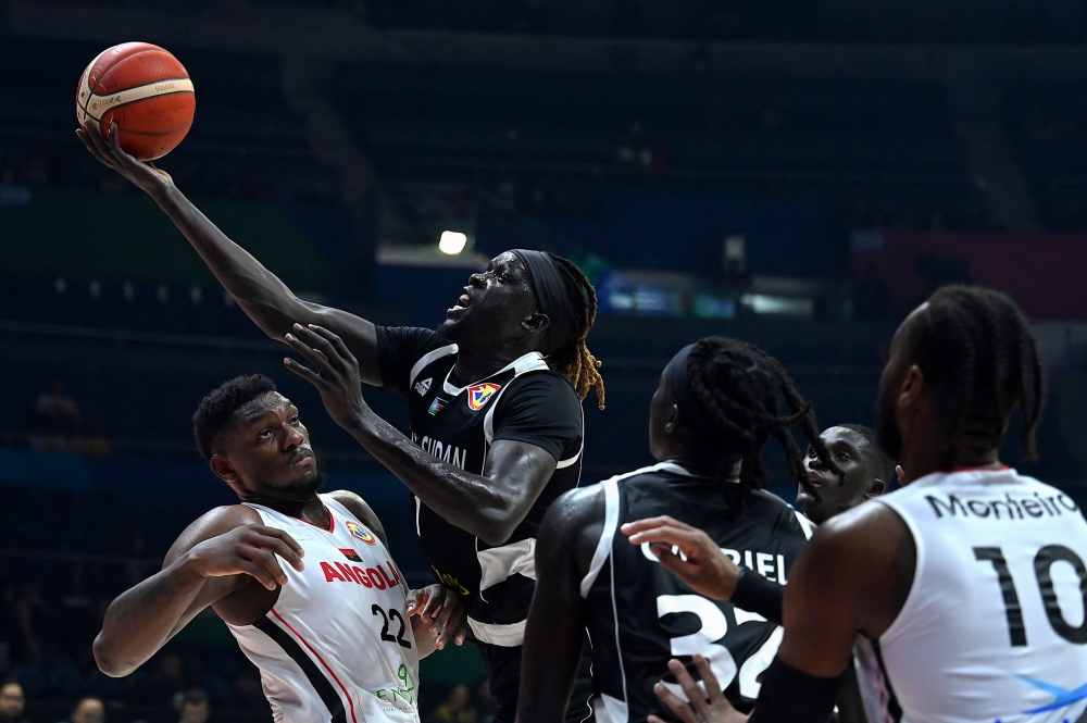 South Sudan's Nuni Omot (2L) shoots the ball during the FIBA Basketball World Cup match between Angola and South Sudan at Smart Araneta Coliseum in Quezon City on September 2, 2023. (Photo by JAM STA ROSA / AFP)
