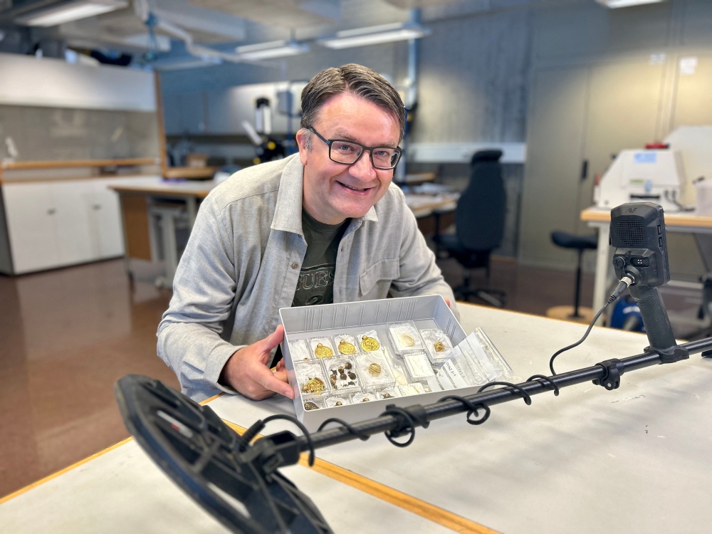 Handout photo released on September 7, 2023, by the Museum of Archaeology and the University of Stavanger (UiS) shows amateur archaeologist Erlend Bore posing with gold treasure in Stavanger. (Photo by Anniken Celine Berger / various sources / AFP) 