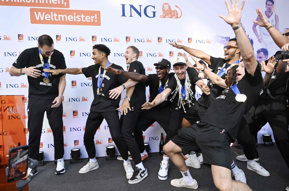 Members of the German Basketball world champions cheer with their trophy to celebrate their victory on September 12, 2023, in the center of Frankfurt, western Germany after they returned from the FIBA Basketball World Cup held in the Philippines. Photo by Kirill KUDRYAVTSEV / AFP