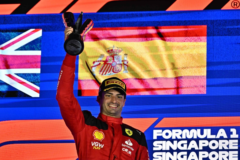 Ferrari's Spanish driver Carlos Sainz Jr celebrates on the podium after winning the Singapore Formula One Grand Prix night race at the Marina Bay Street Circuit in Singapore on September 17, 2023. (Photo by Lillian Suwanrumpha / AFP)