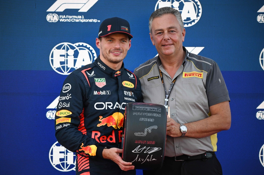 Red Bull Racing's Dutch driver Max Verstappen (L) poses with Pirelli F1 boss Mario Isola after taking the poll position. (Photo by Peter PARKS / AFP)