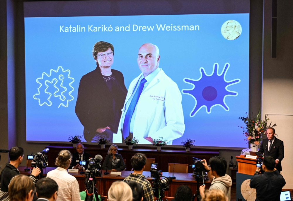 A screen at the Karolinska Institute shows this year's laureates Katalin Kariko of Hungary (L) and Drew Weissman of the US during the announcement of the winners of the 2023 Nobel Prize in Physiology or Medicine at the Karolinska Institute in Stockholm on October 2, 2023. (Photo by Jonathan NACKSTRAND / AFP)
