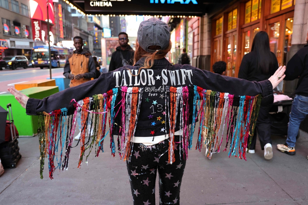 A fan poses before attending the opening night theatrical release of 