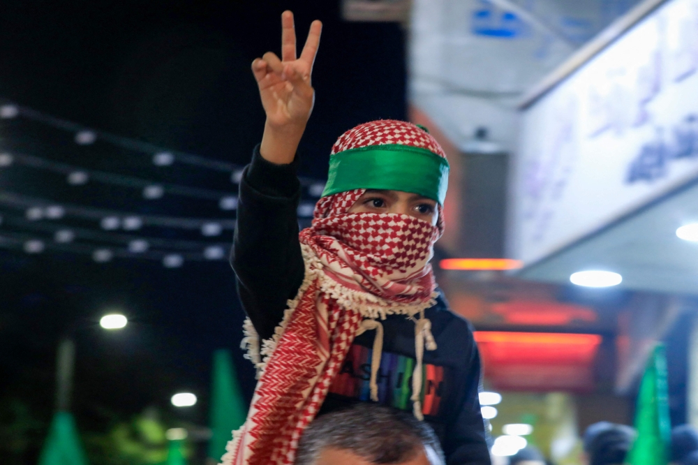 A Palestinian boy flashes the victory sign during a protest in Nablus city in the occupied West Bank on October 17, 2023. (Photo by Zain JAAFAR / AFP)