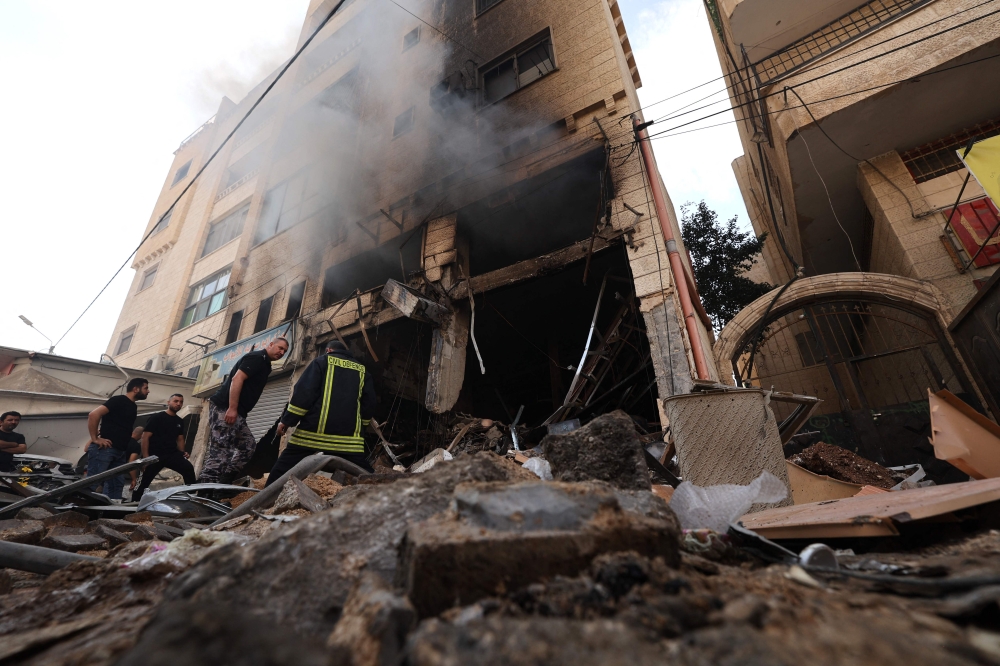 Palestinian firefighters survey damaged stores following an Israeli military raid on the Jenin Palestinian refugee camp, in Jenin in the occupied northern West Bank on October 30, 2023. (Photo by Jaafar Ashtiyeh / AFP)
