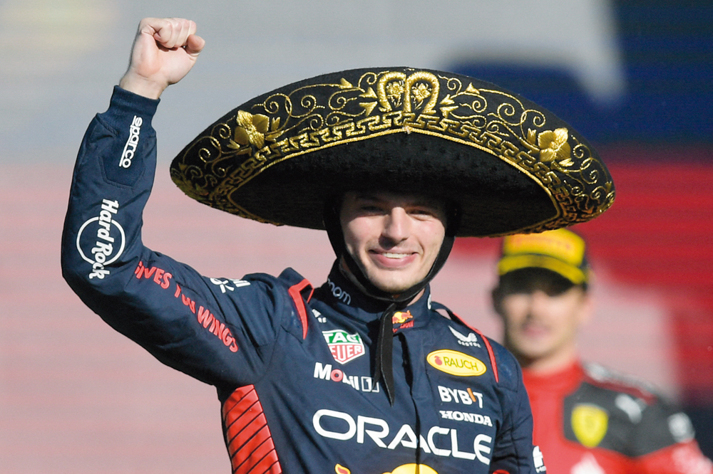 Verstappen celebrates on the podium after winning the race. AFP